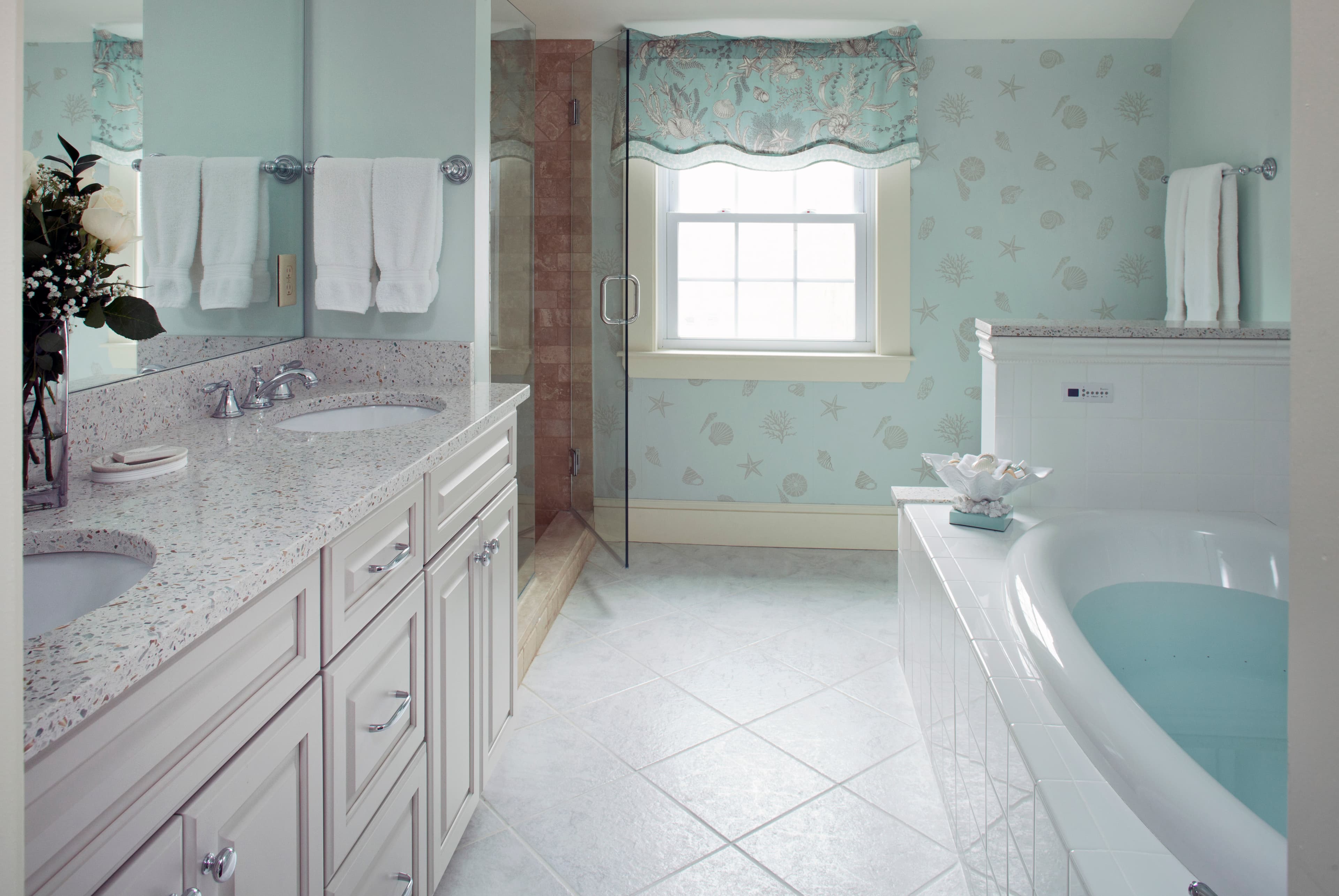 A spacious and elegant bathroom with a double vanity, walk-in shower, and a large soaking tub.