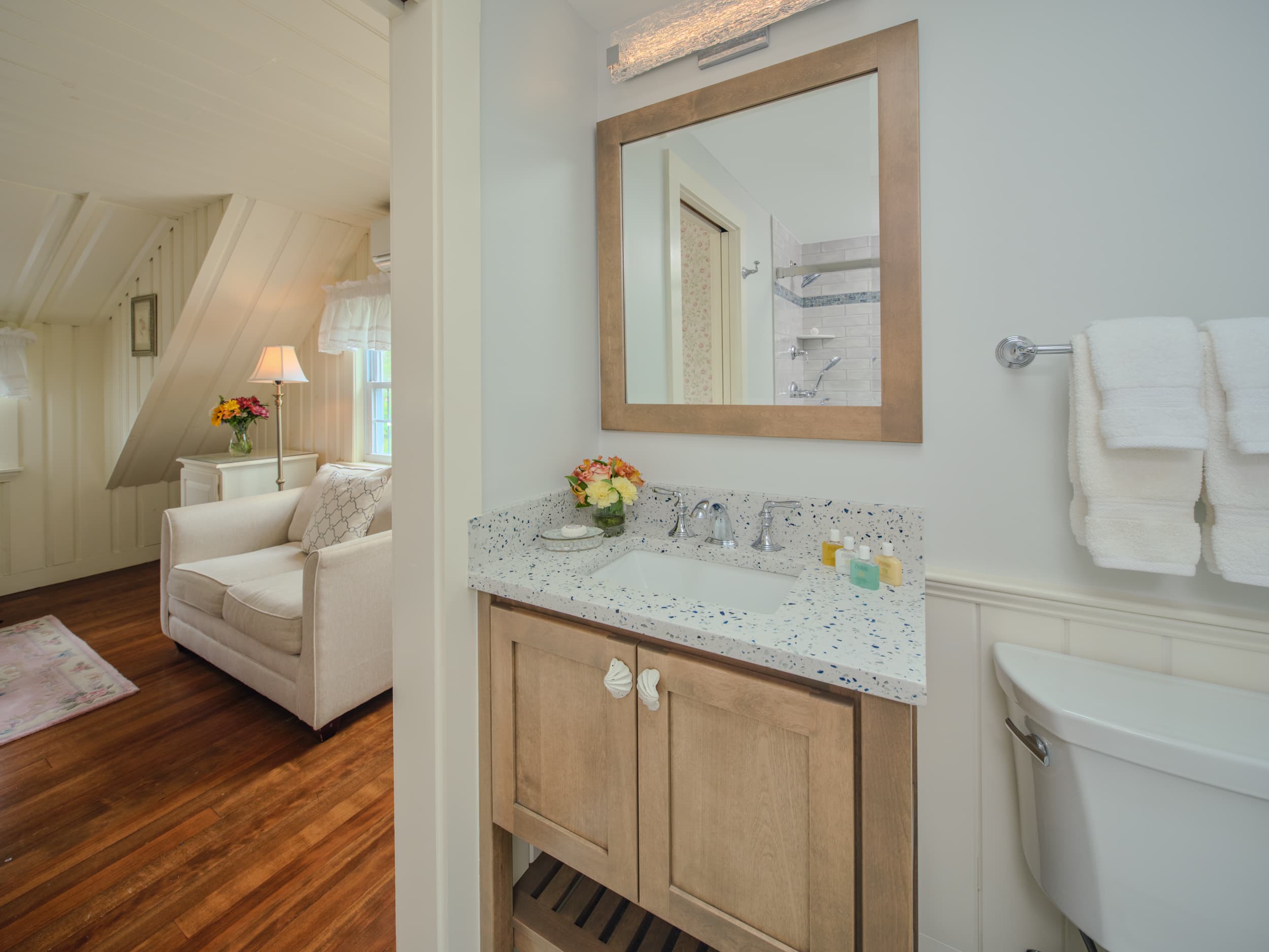 A bathroom with a vanity and a mirror is visible.