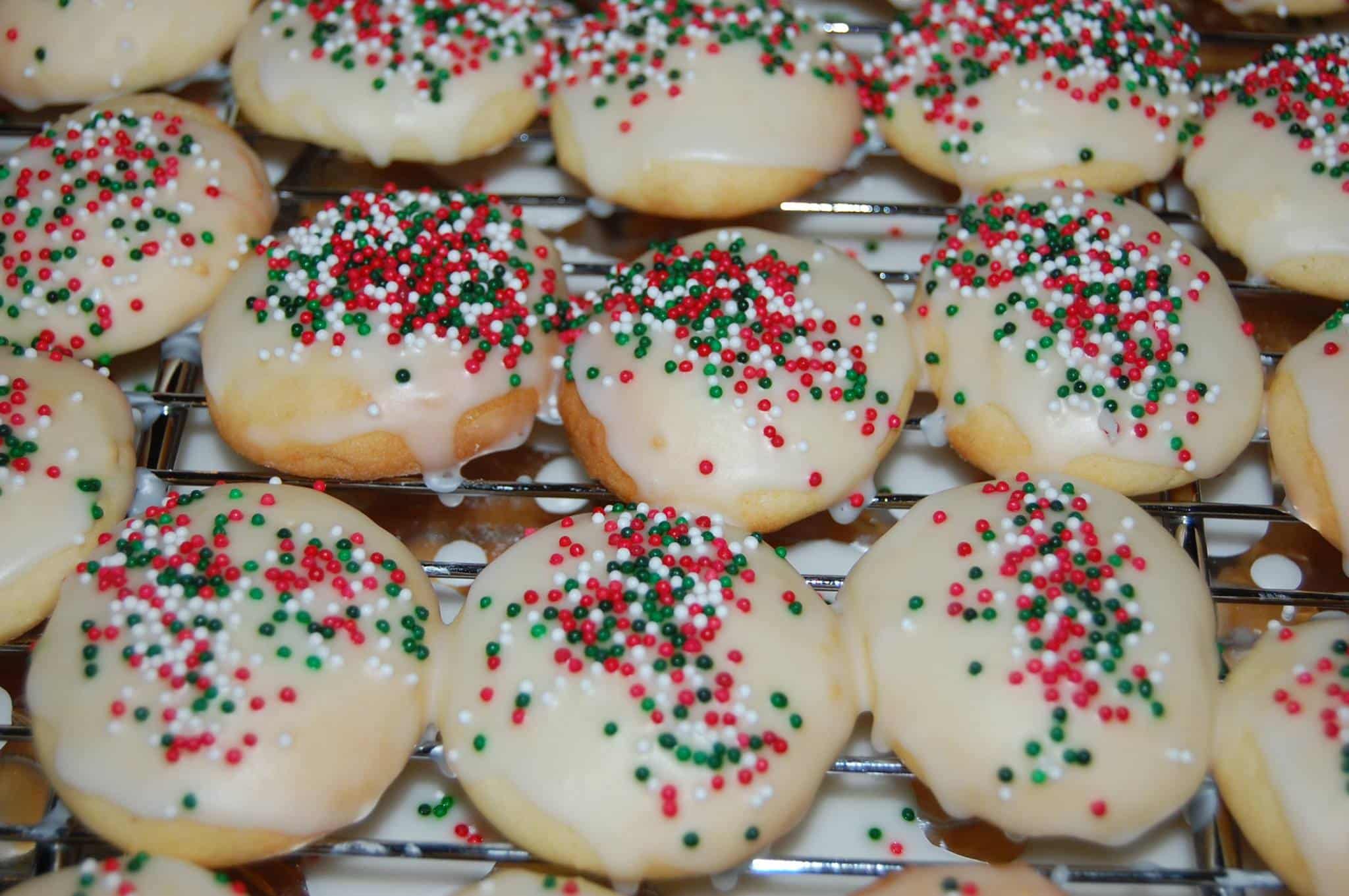 A tray of iced cookies topped with red, green, and white sprinkles. A tray of iced cookies topped with red, green, and white sprinkles.