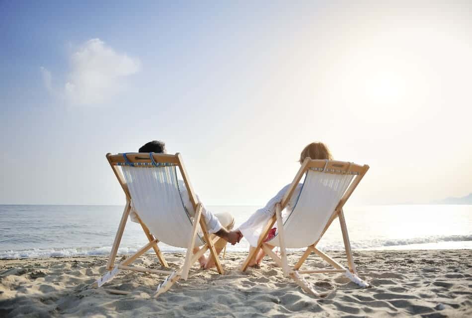 A couple relaxes on beach chairs, enjoying the ocean view at sunset. A couple relaxes on beach chairs, enjoying the ocean view at sunset.