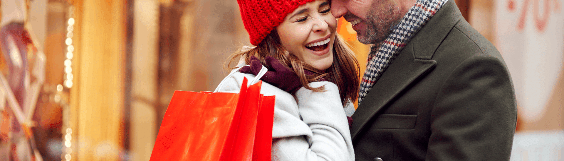 A young couple Christmas shopping & laughing