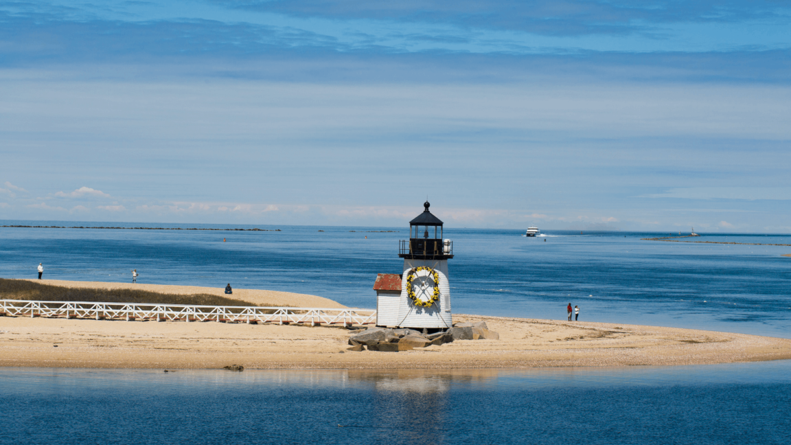 Lighthouse surrounded by the ocean and decorated with flower wreath